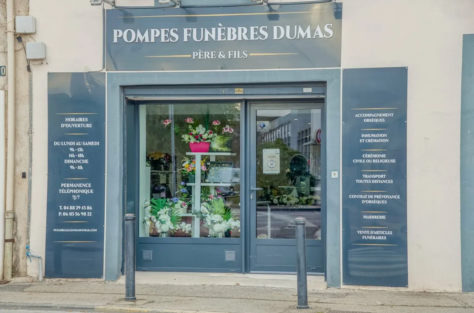 Devanture et vitrine de l'agence de pompes funèbres avec fleurs artificielles.
